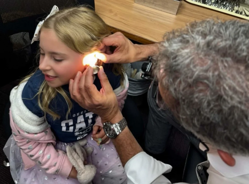 Dr Simon Braham examining a child's ear during an ENT consultation in Melbourne